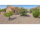 The spacious backyard features desert landscaping, mature trees, and a charming patio seating area at 10428 Villa Ridge Dr, Las Vegas, NV 89134
