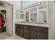 Bathroom featuring double sinks, granite counters, dark wood vanity and walk-in closet access at 10428 Villa Ridge Dr, Las Vegas, NV 89134