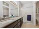 Bright bathroom showcasing double sinks, granite counters, dark wood vanity and framed glass-door shower at 10428 Villa Ridge Dr, Las Vegas, NV 89134