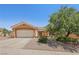 Tan single-story house featuring desert landscaping, a spacious driveway, and an attached garage at 10428 Villa Ridge Dr, Las Vegas, NV 89134