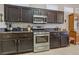Modern kitchen featuring stainless steel range, dark wood cabinets, granite countertops, and ample storage space at 10428 Villa Ridge Dr, Las Vegas, NV 89134