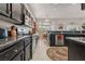 Stylish kitchen featuring dark cabinetry, granite countertops, and stainless steel appliances, open to the dining area at 10428 Villa Ridge Dr, Las Vegas, NV 89134
