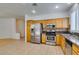 Modern kitchen with tile floors, wood cabinets and stainless steel appliances at 10513 Shanna Trellis Ave, Las Vegas, NV 89144