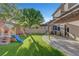 Expansive backyard showcases artificial turf, a play structure, a patio, and outdoor kitchen at 1069 Aspen Cliff Dr, Henderson, NV 89011