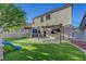 Spacious backyard with manicured artificial grass, outdoor kitchen, and pergola-covered patio at 1069 Aspen Cliff Dr, Henderson, NV 89011