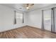 Cozy bedroom with neutral walls, wood-look flooring, and curtained windows at 1069 Aspen Cliff Dr, Henderson, NV 89011