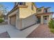 Beige two story stucco house featuring a tile roof, a front entry and an attached two car garage at 1069 Aspen Cliff Dr, Henderson, NV 89011