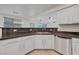 Kitchen area with stainless steel dishwasher, white cabinets, and tile backsplash at 1069 Aspen Cliff Dr, Henderson, NV 89011