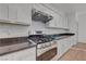Modern kitchen features stainless steel appliances and white cabinets with dark countertops at 1069 Aspen Cliff Dr, Henderson, NV 89011