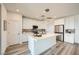 Modern kitchen boasts white cabinetry, stainless steel appliances, and center island with bar seating at 12093 Glentana View St, Las Vegas, NV 89138