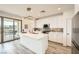 Bright, modern kitchen features a center island, white cabinets, and sliding glass door to patio at 12093 Glentana View St, Las Vegas, NV 89138