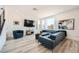 Comfortable living room featuring modern decor, a large sectional sofa, and wood-look flooring at 12093 Glentana View St, Las Vegas, NV 89138
