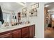Bright bathroom with double sinks, white countertops, wood cabinets, and a walk-in closet at 135 Cadrow Castle Ct, Las Vegas, NV 89148