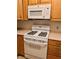 White range with microwave and wooden cabinets for kitchen storage at 1409 Santa Margarita St # B, Las Vegas, NV 89146