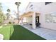 Backyard with a covered patio, artificial turf, and mature landscaping at 1700 Double Arrow Pl, Las Vegas, NV 89128