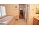 Bathroom with soaking tub, tile floor and a hallway view to the bedroom at 1700 Double Arrow Pl, Las Vegas, NV 89128