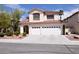 Inviting two-story home with a spacious three-car garage and well-maintained front yard at 1700 Double Arrow Pl, Las Vegas, NV 89128