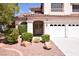 Home featuring manicured landscaping leading up to a covered front entryway at 1700 Double Arrow Pl, Las Vegas, NV 89128