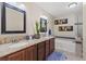 Beautiful bathroom featuring a double vanity, granite counters, soaking tub, and tiled shower at 1911 Valley Dr, Las Vegas, NV 89108
