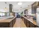 Spacious kitchen with stone countertops, stainless appliances, dark wood cabinets, and eat-in breakfast area at 1911 Valley Dr, Las Vegas, NV 89108