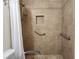 Close-up of neutral tiled walk-in shower with safety bars and handheld showerhead at 2016 Mesquite Ln # 104, Laughlin, NV 89029