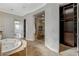 Bathroom featuring large soaking tub, glass enclosed shower and access to the walk-in closet at 2172 De Rouge Ave, Henderson, NV 89044