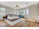 Bright main bedroom features hardwood floors, an inviting chaise, and three large windows at 2172 De Rouge Ave, Henderson, NV 89044