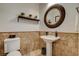 Charming powder room with tiled accent wall, pedestal sink, and decorative mirror at 2172 De Rouge Ave, Henderson, NV 89044