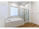 Relaxing bathroom featuring a soaking tub, glass shower, and elegant tile work at 218 Vista Balla Ave, Las Vegas, NV 89138