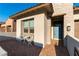 Charming entrance with a cozy seating area, brick-paved patio, and stylish blue front door at 218 Vista Balla Ave, Las Vegas, NV 89138