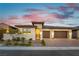 Charming single-story home with a two-car garage and manicured landscaping at twilight at 218 Vista Balla Ave, Las Vegas, NV 89138