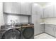 Convenient laundry room with modern washer and dryer, ample storage, and stylish tile flooring at 218 Vista Balla Ave, Las Vegas, NV 89138