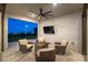 Covered outdoor patio with comfortable seating, a fire pit, and a view of the city skyline at night at 218 Vista Balla Ave, Las Vegas, NV 89138