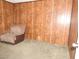 Living room featuring wood panel walls, soft recliner chair, and carpeted floors at 2813 Willoughby Ave, Las Vegas, NV 89101