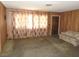 Living room featuring wood paneling, neutral carpet and simple furnishings at 2813 Willoughby Ave, Las Vegas, NV 89101