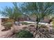 Landscaped backyard with trees, gravel beds, a seating area, and a grass patch at 3012 Chiefs Ct, North Las Vegas, NV 89032