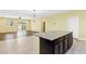 Open kitchen with a granite island, tile floors, a pendant light, and access to the living room at 3012 Chiefs Ct, North Las Vegas, NV 89032