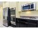 Modern kitchen featuring stainless steel appliances, granite countertops, and sleek black cabinetry at 3012 Chiefs Ct, North Las Vegas, NV 89032