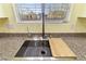 Close-up of a modern stainless steel kitchen sink and faucet set against granite countertops at 3012 Chiefs Ct, North Las Vegas, NV 89032