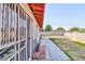 A long, partially grassy backyard behind a white one-story house with white metal security bars at 304 Perkins Cir, Las Vegas, NV 89106