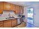 Efficient kitchen with stainless steel appliances, wood cabinets, and a door leading to the outdoor space at 304 Perkins Cir, Las Vegas, NV 89106