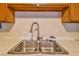 Close-up of a stainless steel kitchen sink with modern fixtures and white countertops at 304 Perkins Cir, Las Vegas, NV 89106