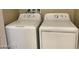 Functional laundry area with standard sized white washer and dryer units ready for use at 31 White Burch Ln, Pahrump, NV 89048