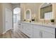 Modern bathroom featuring dual sinks, backlit mirrors, and wood plank walls at 3218 Squire St, Las Vegas, NV 89135