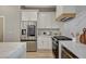 Modern kitchen with stainless steel appliances, white cabinets, quartz countertops, and gas range at 3218 Squire St, Las Vegas, NV 89135