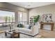 Bright living room featuring large windows, plush seating, stylish decor, and wood-look flooring at 3218 Squire St, Las Vegas, NV 89135