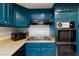 Close up on traditional kitchen with teal cabinets, laminate countertops, and vintage oven at 3380 Kensbrook St, Las Vegas, NV 89121