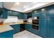 Traditional kitchen featuring teal cabinets, laminate countertops, and tile floors at 3380 Kensbrook St, Las Vegas, NV 89121