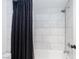 Bathroom with black shower curtain and white tile at 3380 Kensbrook St, Las Vegas, NV 89121