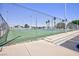 Fenced tennis court with net, poles, and space for active play at 3380 Kensbrook St, Las Vegas, NV 89121